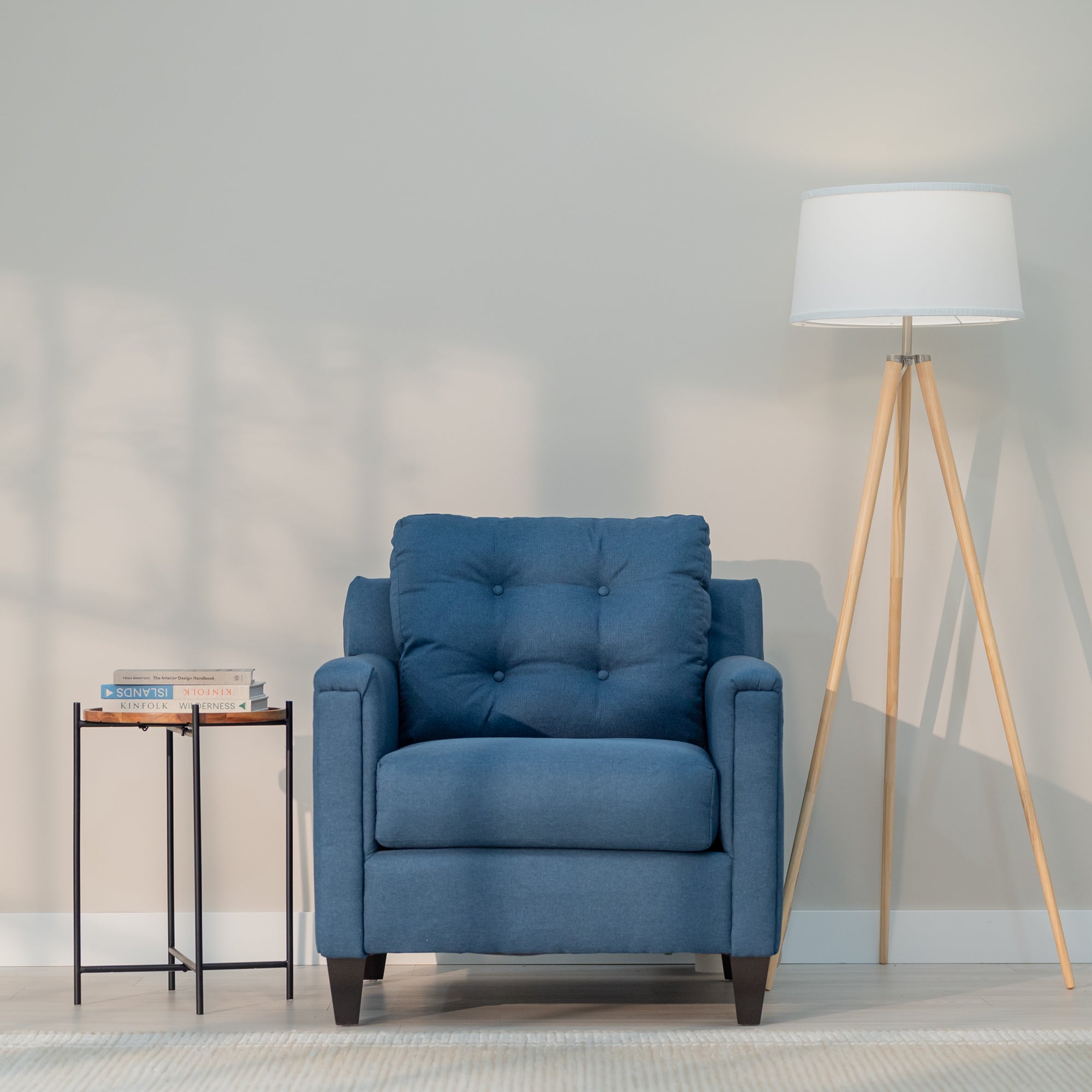 A front view of the denim blue chair showing it modern rectangular shape and plush looking tufted back.