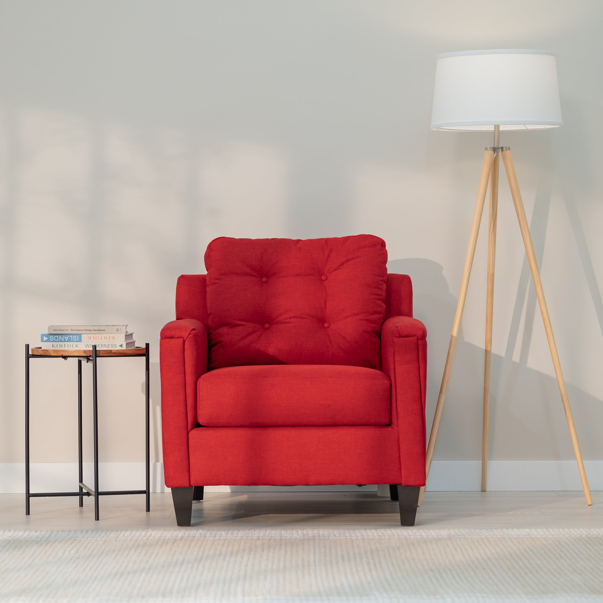 A front view of the red chair showing it modern rectangular shape and plush looking tufted back.