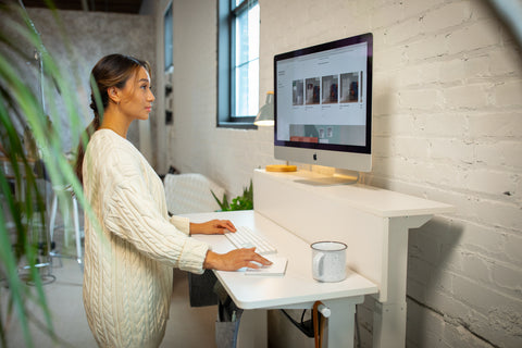 a women works at white ergonomic desk in a stylish loft