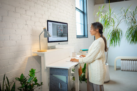 women stands at desk in sunny loft